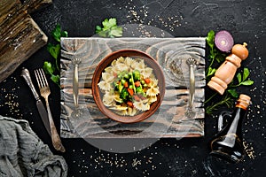 Farfalle pasta with vegetables on the plate.