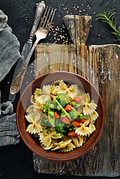 Farfalle pasta with vegetables on the plate.