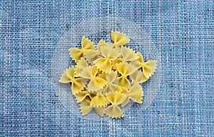 Farfalle macaroni A handful of macaroni on a rustic blue textured background. A view from the top, a close-up of a photo