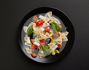 Farfalle salad on black plate