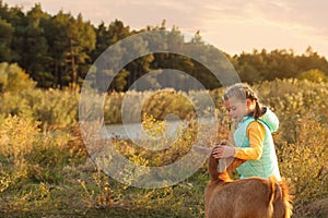 Farm animal. Cute little girl with goat on pasture, space for text