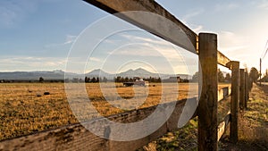 A farm with an antique Dodge truck in a pasture during golden hour with the Oregon Cascades in the background