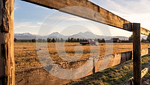 A farm with an antique Dodge truck in a pasture during golden hour with the Oregon Cascades in the background