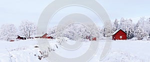 Farm barn and house surrounded by frosty trees