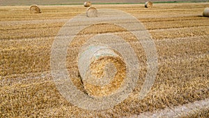 A farm field after harvest with haystacks