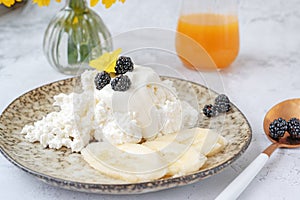 Farm fresh cottage cheese with berries and banana slices. Early breakfast of cottage cheese with fruit and natural juice