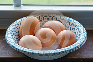 Farm fresh eggs in a paper bowl on a windowsill