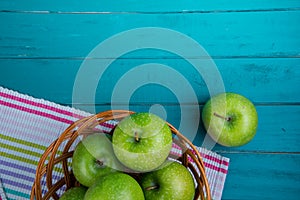 Farm fresh organic green apples in basket on wooden retro blue