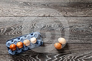 Farm fresh organic large brown and white eggs in carton on rustic dark oak wood background table.