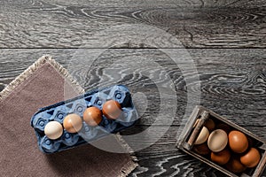 Farm fresh organic large brown and white eggs in carton on rustic dark oak wood background table.