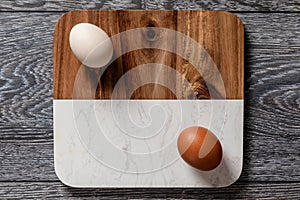 Farm fresh organic large brown and white eggs in carton on rustic dark oak wood background table.