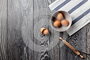 Farm fresh organic large brown and white eggs in egg carton on rustic dark oak wood background table.