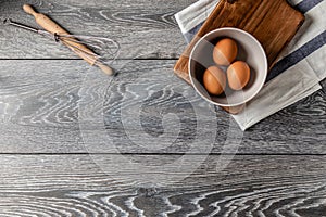 Farm fresh organic large brown and white eggs in egg carton on rustic dark oak wood background table.