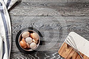 Farm fresh organic large brown and white eggs in egg carton on rustic dark oak wood background table.