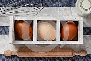 Farm fresh organic large brown and white eggs on a kitchen linen  on rustic dark oak wood background table.