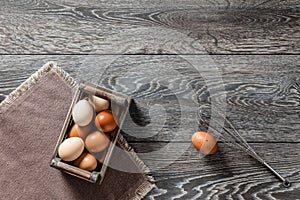 Farm fresh organic large brown and white eggs in wooden crate on rustic dark oak wood background table.