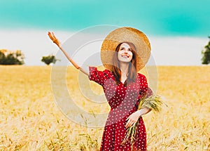 Farm girl holding wheat ears on a field