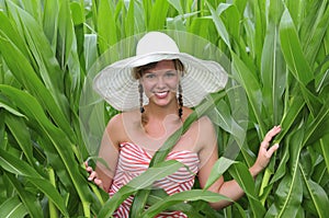 Farm girl standing in a corn field