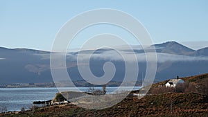 Farm house and misty mountain from Storlauvoya on the Atlantic road in More og Romsdal in Norway