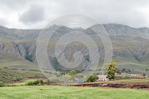 Farm landscape with a vehicle visible on the Swartberg Pass