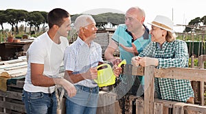 Farm neighbors talk at the border of the garden plot