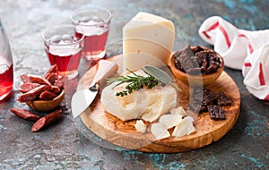 Farm organic goat cheeses, beef smoked sausages, dried deer meat on a wooden board