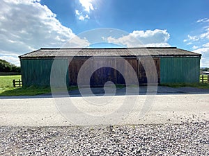 Farm shed, painted green, and brown near, Bolton by Bowland, Clitheroe, UK