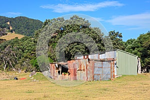 Farm sheds, one old and crumbling, in a rural landscape. New Zealand