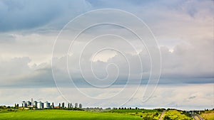 Farm silos at a distant farm at sunset.
