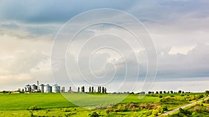 Farm silos at a distant farm at sunset.
