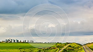 Farm silos at a distant farm at sunset.