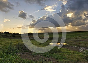 Farm Sunset with grey clouds and sun rays landscap