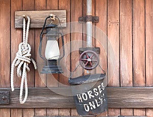 Farm tools rope, lamp, horse bucket hanging on wooden wall - r