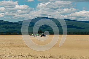 Farm tractor drives in field