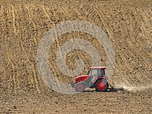 Farm tractor harrowing arable field