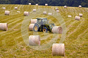 Farm tractor moving hay bales