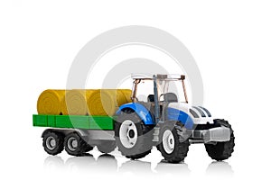 Farm tractor toy with hay trailer, isolated on white