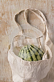 Farm watermelon in koton eco bag on wooden background photo