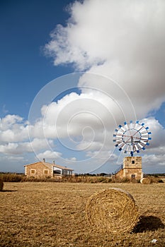 Farm windmill and hay bale