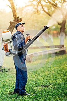 farm worker gardening and spraying pesticide