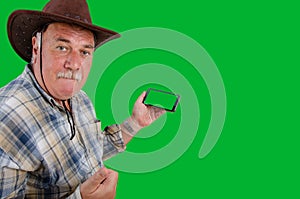 A farmer advertises something holding a smartphone with a green screen.