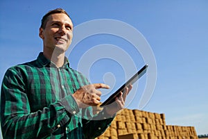 Farmer agronomist with digital tablet computer using mobile app in wheat crops field