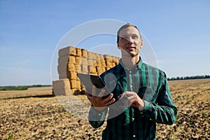 Farmer agronomist with digital tablet computer using mobile app in wheat crops field