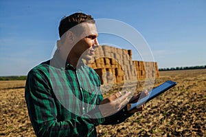 Farmer agronomist with digital tablet computer using mobile app in wheat crops field