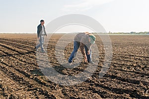 Farmer analyze soya seed after sowing crops at agricultural field in spring