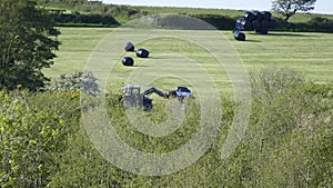 Tractor bailing the hay