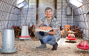 Farmer carrying chicken eggs in coop