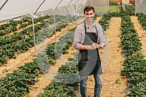 Farmer checking crops in hothouse