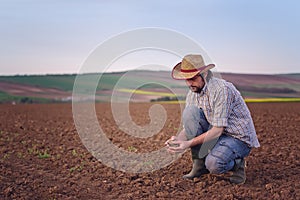 Farmer Checking Soil Quality of Fertile Agricultural Farm Land