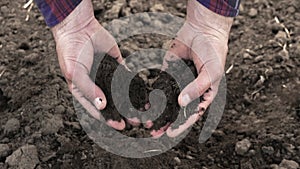 A farmer checks the condition of the land for gardening. Agriculture. Chernozem for growing vegetables.The farmer grabs the ground